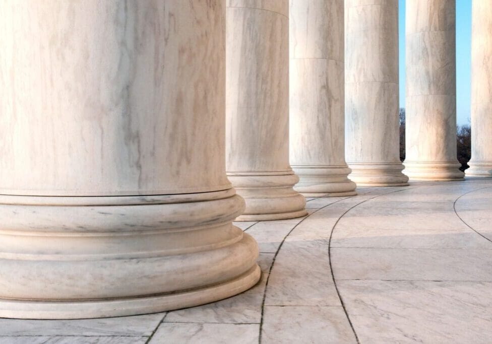 A row of pillars on the side of a walkway.